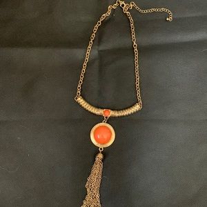 Collar necklace with orange stone pendant and tassel. Antique gold finish